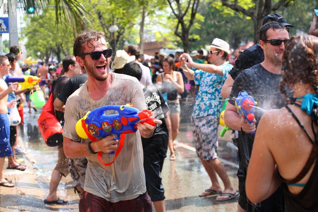 A happy tourist spraying a water gun during Songkran festival, Thailand